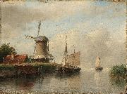 Dutch boats moored on a river beside a windmill